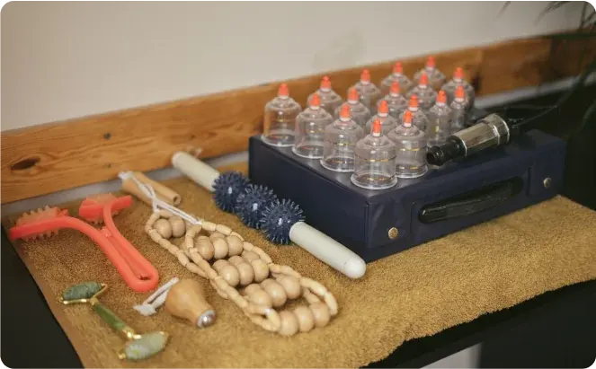 Collection of massage tools including cupping cups, rollers, and jade tools